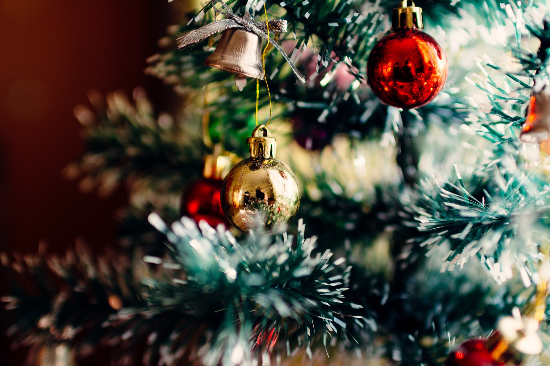 Flocked Christmas tree with glass ornaments in gold and red. Image source Pixabay