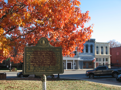 Bourbon County historic marker with an orange maple behind it.